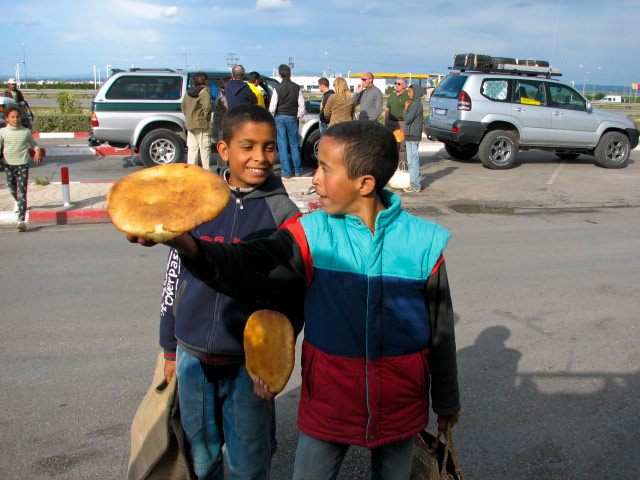 Na bencinski crpalki ob avtocesti južno od Tunisa otroci prodajajo nekakšen kruh. Mudi se nam in boljše kot nic je :) Foto Aleš