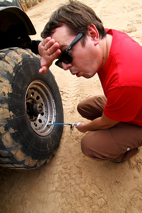 Priprava na zabavo v pesku - spuscanje tlaka v pnevmatikah. Tezko delo za sovoznika. Tukaj se nismo vedeli, da manometer ne kaze prav.