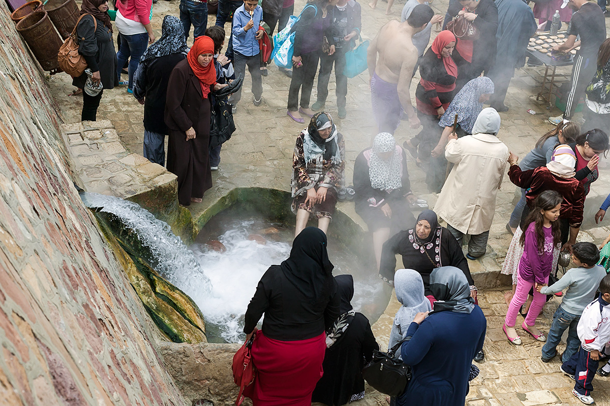 Lokalne gospe uzivajo prost dan v Korbousu, kjer se termalni vrelec izliva skoraj naravnost v morje.